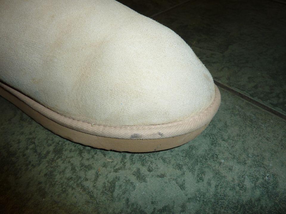 Beige boot toe with dirt smudges and Supermotors logo at bottom right