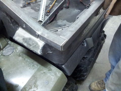 1990 Chevrolet Suburban - An ATV's cargo bed is being fitted with a custom metal frame, with another ATV partially visible.