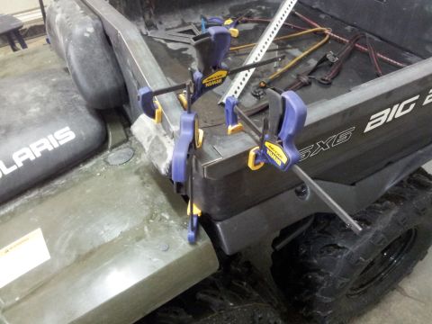 1990 Chevrolet Suburban - An all-terrain vehicle's bed is being modified with metal bracing and clamps.