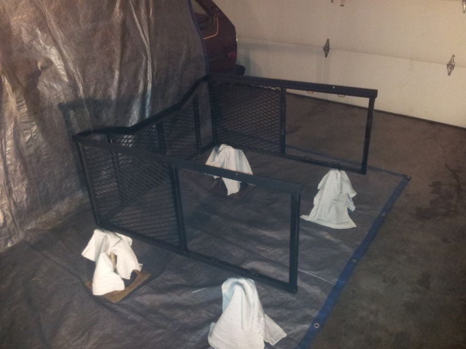 Black metal cargo carrier with white cloths on a tarp