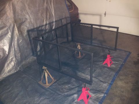 1990 Chevrolet Suburban - A truck bed rack is assembled on jack stands, covered by a tarp in a garage.