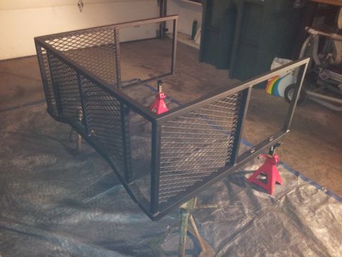 1990 Chevrolet Suburban - A metal cargo carrier frame is shown, supported by red jack stands in a garage setting.