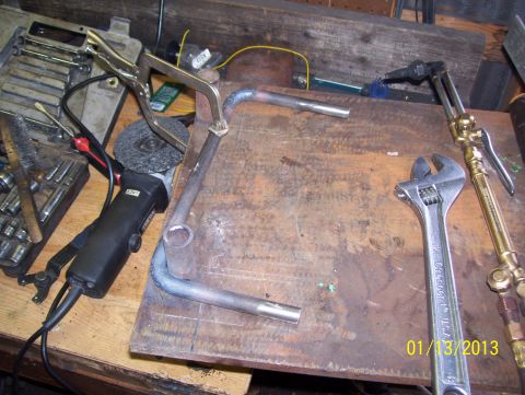 1990 Ford Bronco - Metal grab handle fabrication in progress, with tools including a grinder, torch, and adjustable wrench.
