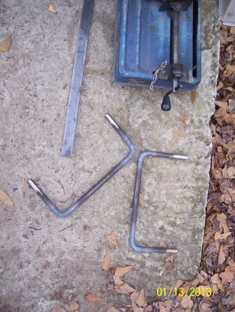 1990 Ford Bronco - Metal grab handles and a chop saw are laid out on a concrete surface with fallen leaves.