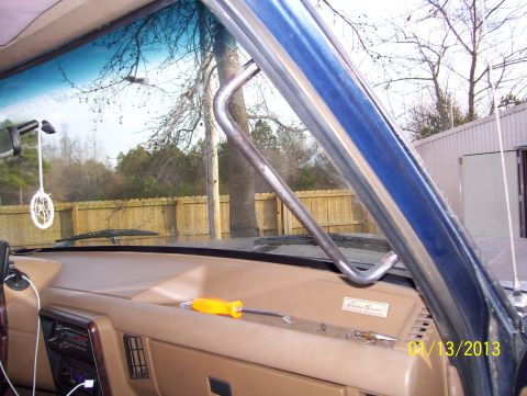 1990 Ford Bronco - A metal grab handle is visible inside a vehicle, mounted near the windshield and dashboard.