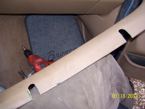 1990 Ford Bronco - A close-up view of an interior trim piece with a drill and a floor mat visible.