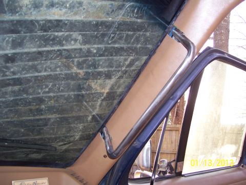 1990 Ford Bronco - A close-up view of an aftermarket grab handle installed on the interior A-pillar of a 1990 Ford Bronco.