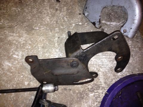 1994 Ford Bronco - A metal bracket is shown on a concrete floor, with other parts visible.