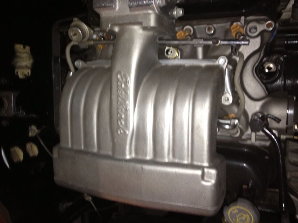 Close-up of an Edelbrock intake manifold with fuel injectors and lines attached