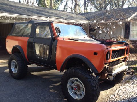 1994 Ford Bronco - This lifted International Harvester Scout II is parked in a driveway with a house in the background.