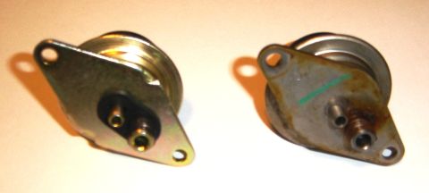 1996 Ford Bronco - Two vacuum actuators are shown, one appearing newer and cleaner than the other, which shows signs of rust and a green marking.