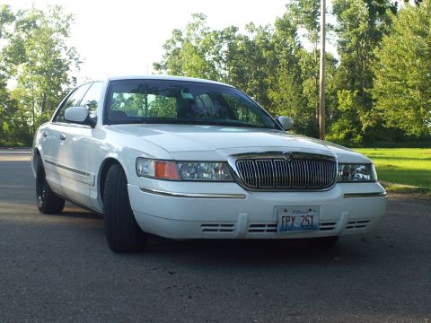 2000 Mercury Grand Marquis - Front view of a white 2000 Mercury Grand Marquis sedan parked on asphalt with trees in the background.