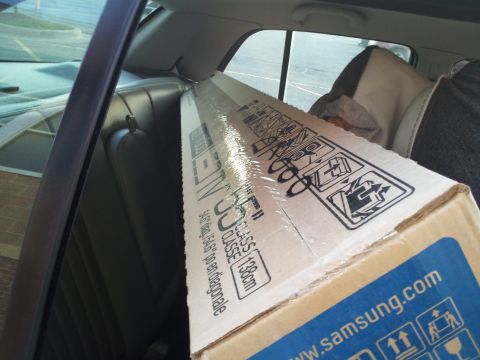 2000 Mercury Grand Marquis - A large Samsung TV box is transported inside a car, taking up the rear seat space.
