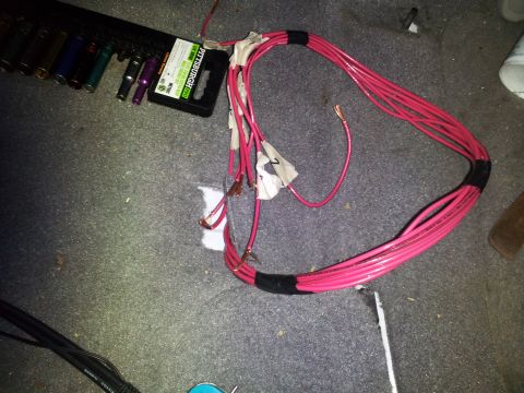 2000 Mercury Grand Marquis - A close-up view of a pink wiring harness and a set of tools laid out on a carpeted surface.