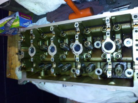 2000 Mercury Grand Marquis - Close-up view of a disassembled engine cylinder head, showing internal components like valves and springs.