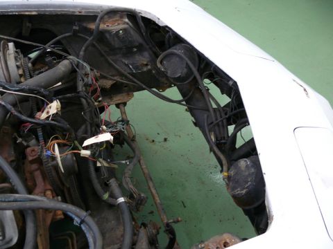 1976 Chevrolet Corvette - Close-up of a car's engine bay, showing complex wiring and plumbing.