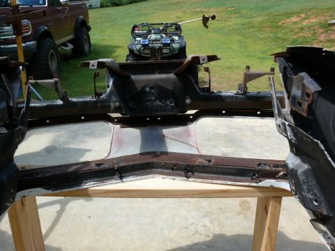 1976 Chevrolet Corvette - A disassembled car frame is shown outdoors with other vehicles in the background.