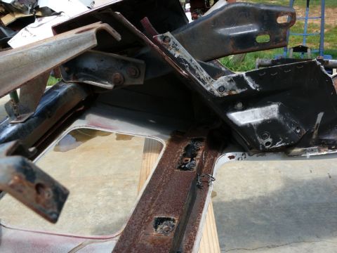 1976 Chevrolet Corvette - Close-up of heavily rusted automotive frame components and structural brackets.