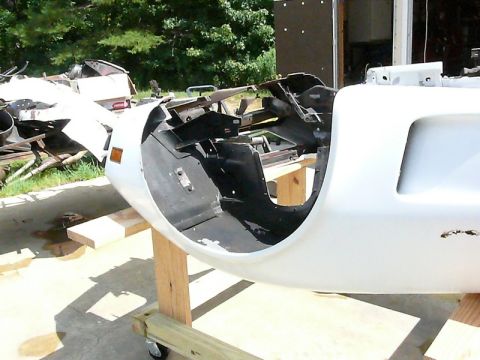 1976 Chevrolet Corvette - The front end of a car is disassembled and mounted on a stand, revealing its internal structure and components.