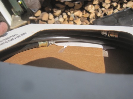 1993 Ford Bronco - A black hose with metal fittings is shown inside a cardboard box with text indicating to remove the cable.
