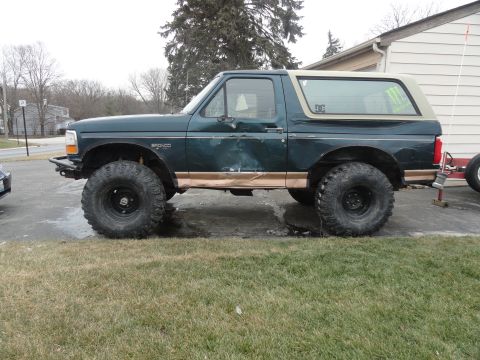 1995 Ford Bronco - This modified Ford Bronco features oversized tires and a lifted suspension, indicating a model year prior to 1997.