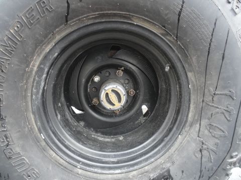 1995 Ford Bronco - A close-up view of a vehicle's wheel and tire, with visible text on the tire sidewall and hubcap.