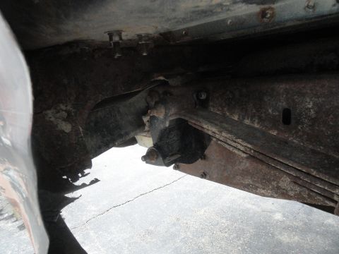 1995 Ford Bronco - Close-up view of the undercarriage, revealing rusted metal and suspension parts.