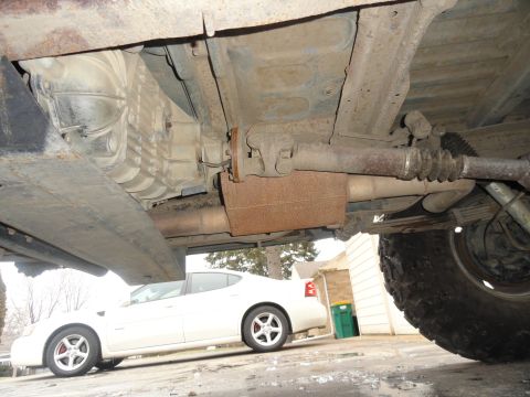 1995 Ford Bronco - The underside of a vehicle is shown, with a white sedan visible in the background.