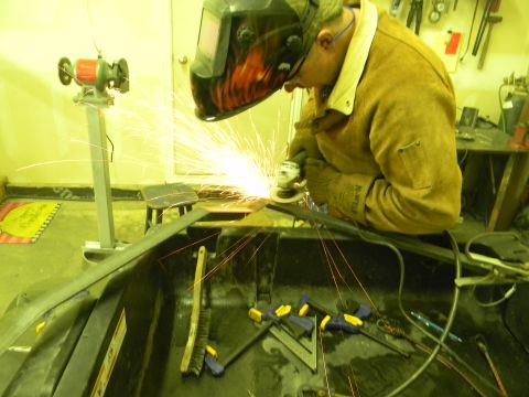 1990 Chevrolet Suburban - Grinding metal sparks fly as a person works in a workshop with various tools around.