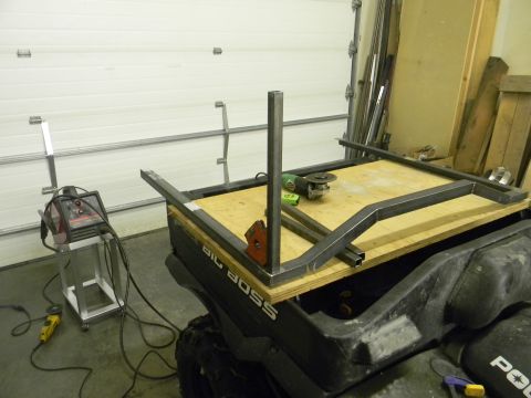 1990 Chevrolet Suburban - An ATV is being modified with a metal frame, with welding equipment and tools present in a garage.