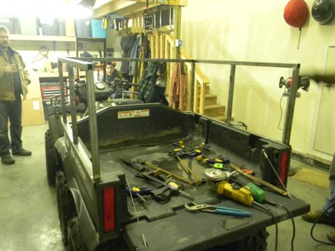 1990 Chevrolet Suburban - An ATV is in a garage, undergoing modifications with a new metal frame being constructed.