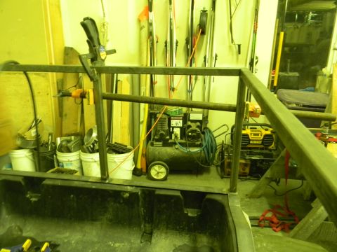 1990 Chevrolet Suburban - Workshop scene with a metal frame, air compressor, and various tools and buckets.