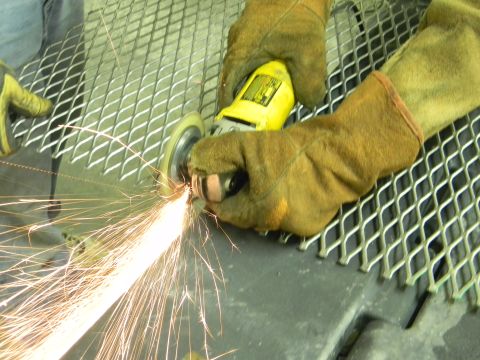 1990 Chevrolet Suburban - Sparks shower from a metal grinding operation, highlighting the intense process of shaping and finishing materials.