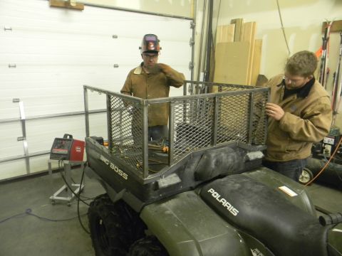 1990 Chevrolet Suburban - Two men are building a custom metal cargo rack onto the back of a Polaris ATV.