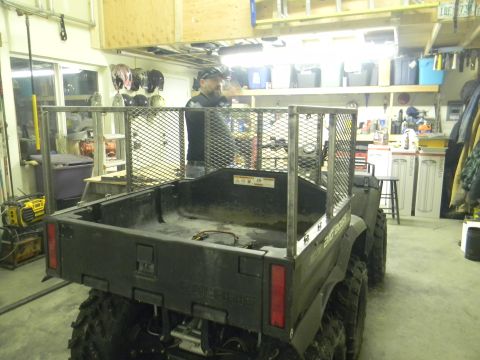 1990 Chevrolet Suburban - An ATV is parked in a garage, a metal cage around its bed and a man standing behind it.
