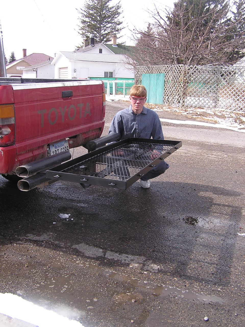 Red Toyota pickup truck rear view with cargo carrier and dual exhaust