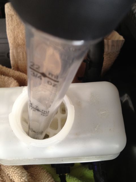 2013 Ford Mustang - A close-up view of a brake fluid reservoir with a measuring tube being used to check the fluid level.