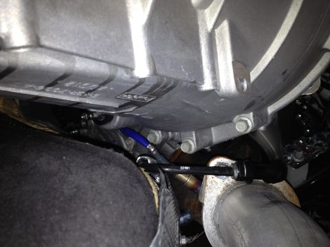 2013 Ford Mustang - Close-up view of a car's transmission housing and exhaust system components.
