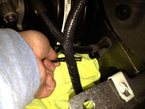 2013 Ford Mustang - Disconnecting a fuel line with a yellow cloth to catch drips.