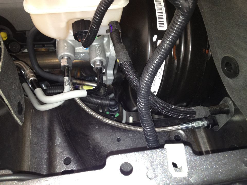 Brake master cylinder and booster assembly with braided lines