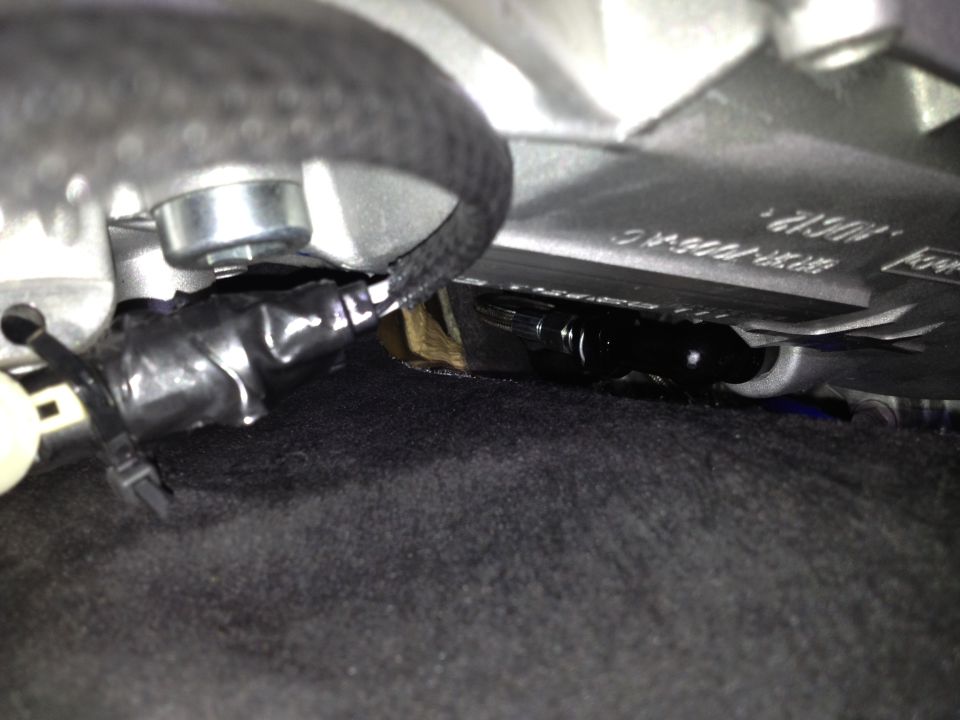 Close-up of black electrical tape wrapped around wires under a car seat