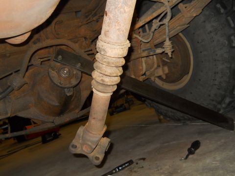 1992 Ford Bronco - Close-up view of the driveshaft and rear differential assembly of a vehicle, likely undergoing maintenance.