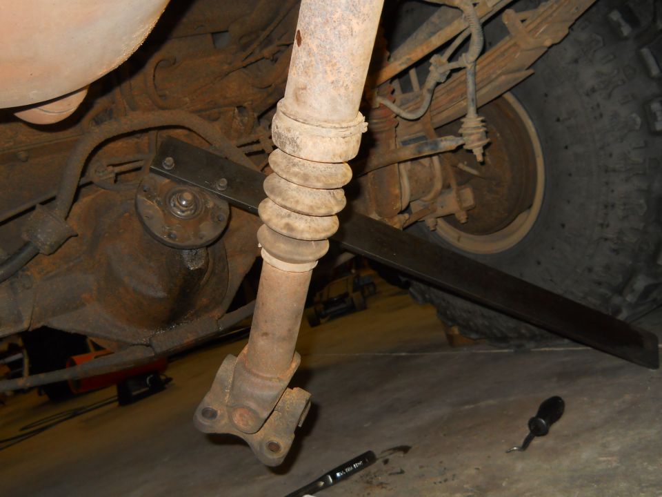 underneath vehicle, driveshaft removed from differential, showing rear axle and tire