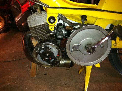 1981 Garelli Rally Sport - The engine and drivetrain components of a yellow moped are shown in detail, supported by wooden blocks.