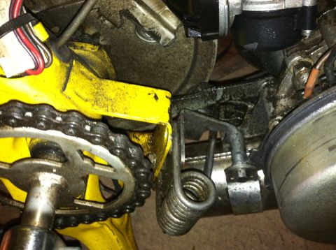 1981 Garelli Rally Sport - Close-up view of a yellow moped's engine components, including the chain and a prominent spring. The Supermotors.net logo is visible in the…