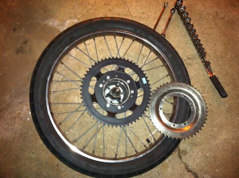 1981 Garelli Rally Sport - A motorcycle wheel, two sprockets, and a chain tool are laid out on a concrete floor.