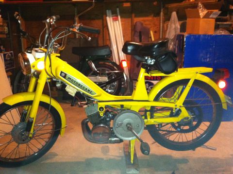 1981 Garelli Rally Sport - A yellow Motobecane moped is shown in a garage setting, with another moped partially visible behind it.