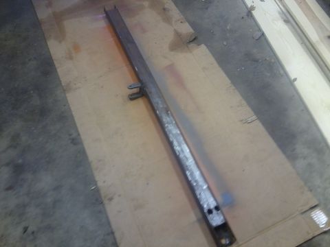 1985 Chevrolet Blazer - Unidentified metal frame part with mounting tabs and holes, placed on cardboard.