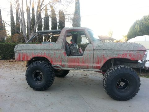 1978 Ford Bronco - This heavily modified 1978 Ford Bronco is coated in mud, oversized tires and an external roll cage.