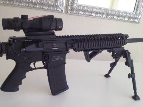 2013 Ford Mustang - AR-15 style rifle equipped with a scope and bipod, "Noveske" and "M&P" markings.
